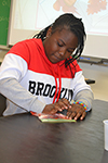 A student mashes strawberries so that she can collect the DNA from it.