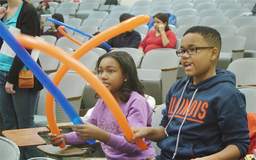 Two young visitors to Mosaic in fall 2014 play with balloons during the Fun with Iterative Balloon-Twisting workshop. (Photo courtesy of Matt Ando.)