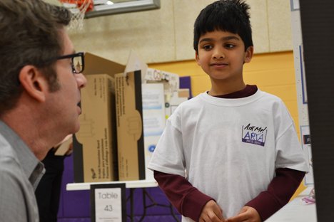 Scott Robinson discusses an NGS student's project during the fair.