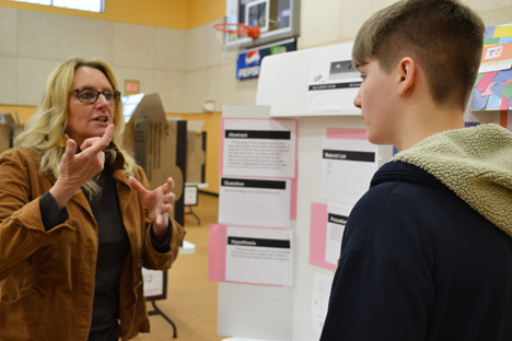 Science Educator and EnLiST Project Coordinator Anita Martin discusses a student's project with him.