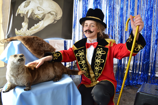 Naturally Illinois Expo exhibitor at the "River Otters in Illinois" exhibit poses by a stuffed otter.