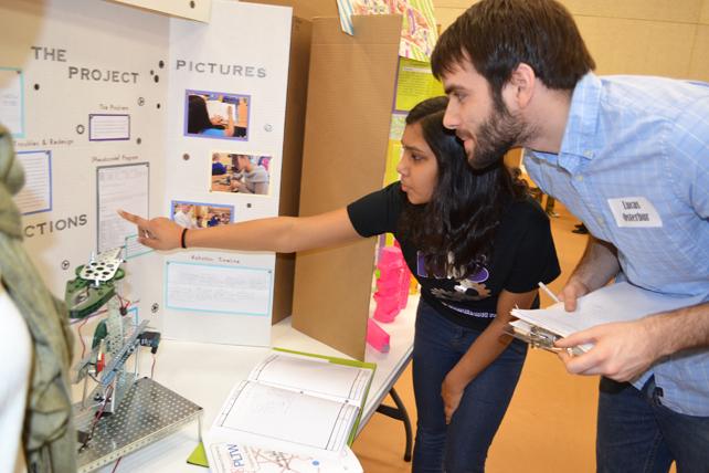 Eighth grader explains the Pick and Place robot she helped design to <em>Illinois'</em> Lucas Osterbur during judging at  Next Generation's Science & Engineering Fair.