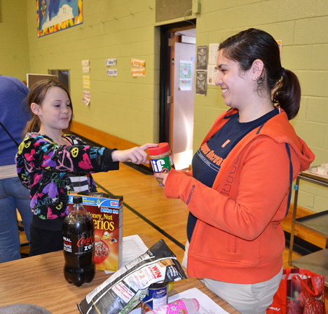 Leila Shinn and a student play a game about nutrition.