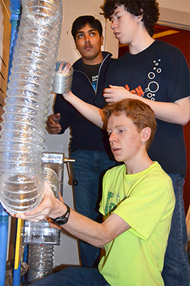 Uni High Students add a section of plastic tubing to the wind maze they're building.