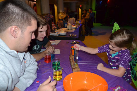 Two REACT students talk a young butterfly through an experiment involving sodium solutions.
