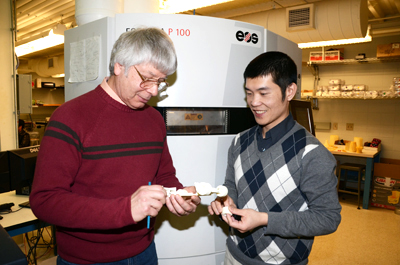 Jim Phillips (left) and Keng Hsu examine a model created in the Ford Manufacturaing Lab
