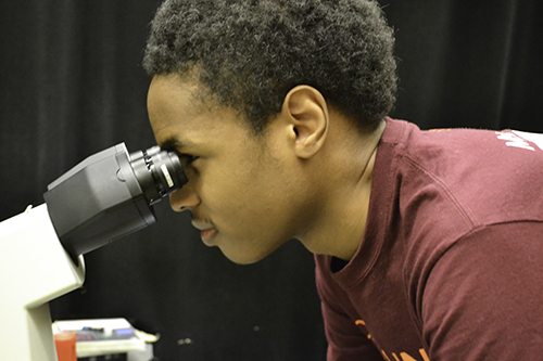 Solomon McBride uses a microscope in ECE professor Gabriel Popescu's lab in Beckman Institute