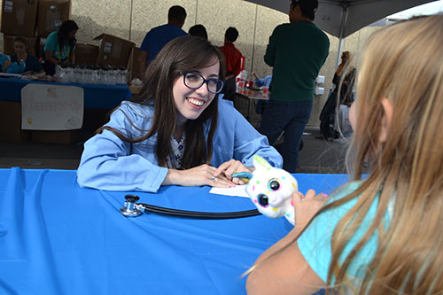 Emma Whitmore interacts with a young visitor who intends to do “surgery” on her stuffed animal.