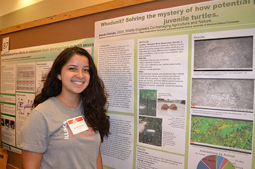 Alondra Estrada with her poster at the Illinois Summer Research Symposium.