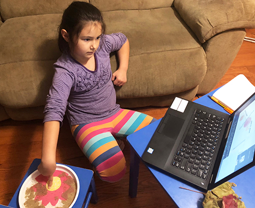 An eight-year-old participating in CyC does the hands-on activity about surface tension on water.