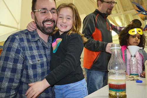 A SWE DADDS participant and her dad have a great time bonding while makeing a rainbow jar.