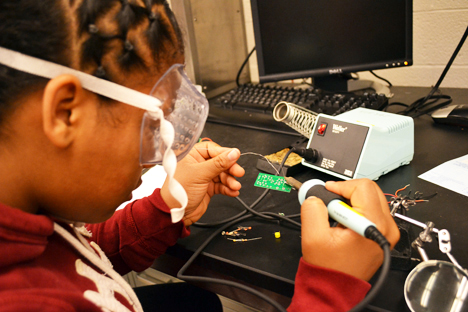 GLEE camper at work soldering a circuit.