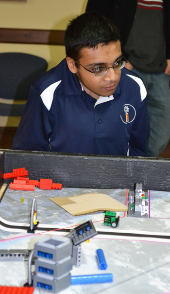 iRobotics Outreach Coordinator Arsalan Aslam watches a team go through a practice run at the practice tournament he organized.