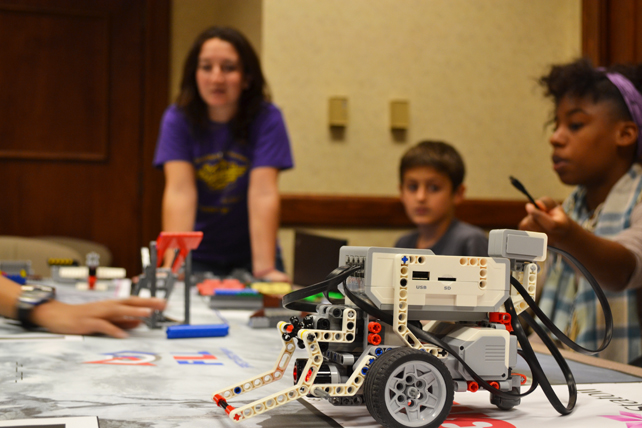 Becca Nothof (left) and a team discuss the success of their robot at the practice competition.