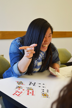 Eileen Ryu enjoying an interaction with a middle school student while playing a math-based card trick at iMATHS.