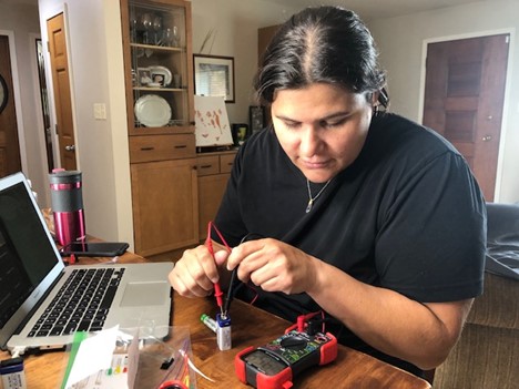 Darienne Ciuro Sanchez, a Dual Language science teacher at Urbana Middle School tests the charge on a battery during a beadboarding activity