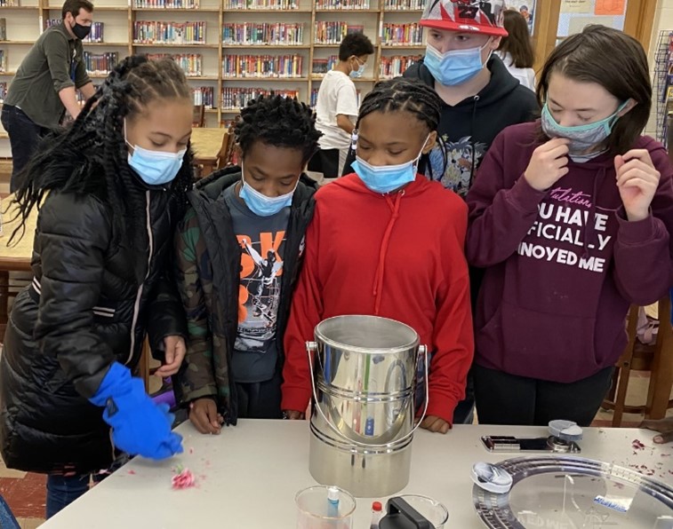 Mason gives students carnations that she’s dipped into a canister of liquid nitrogen to see what happens to the flowers when they get cold.