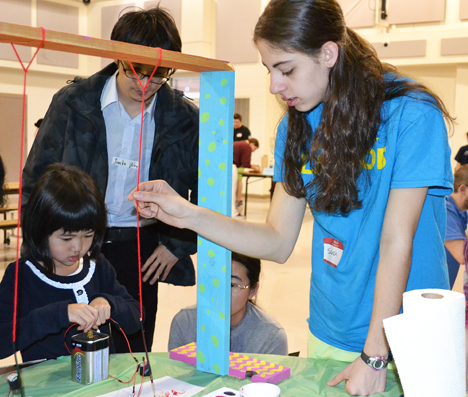 Sarah Stranieri (right) helps 5-year old Kegion do an activity that allows the students to paint using electrical impulses from batteries.