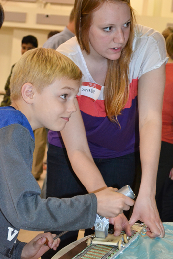 Danielle Malone (right) guides 9-year-old Kevin through how to use the catapult.