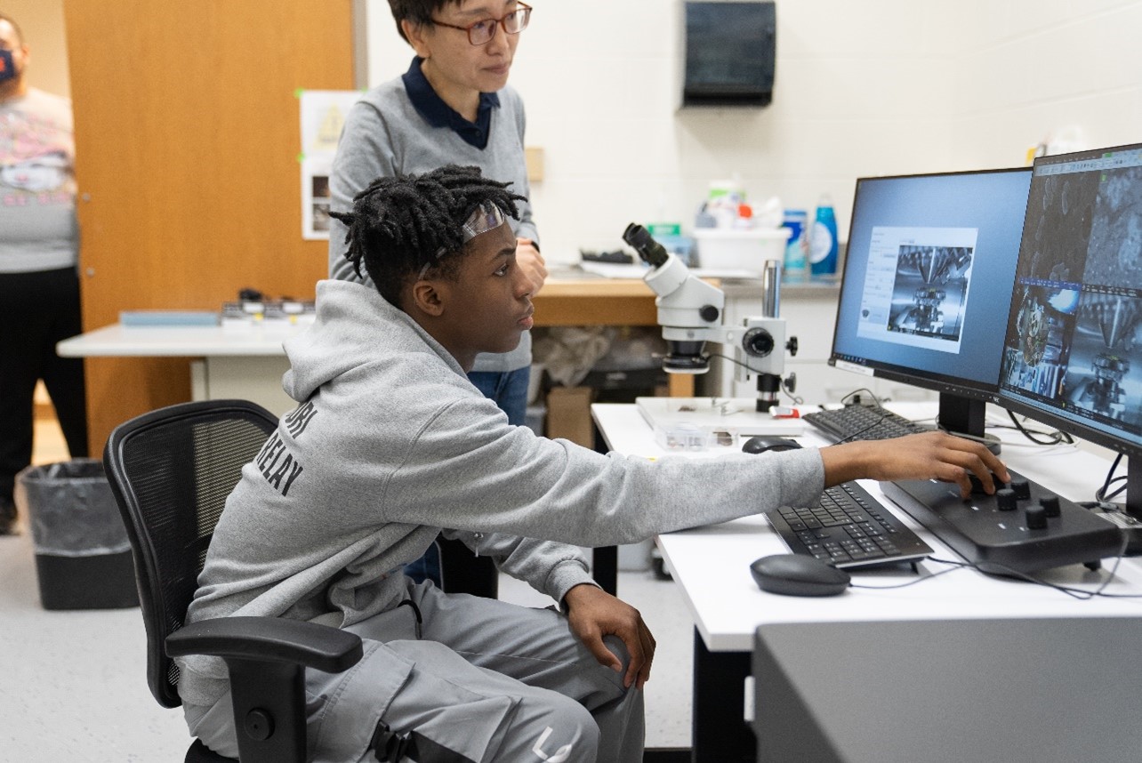 A Franklin student operates a scanning electron microscope with help from MRL staff scientist Dr. Jade Wang Photo by Virgil Ward