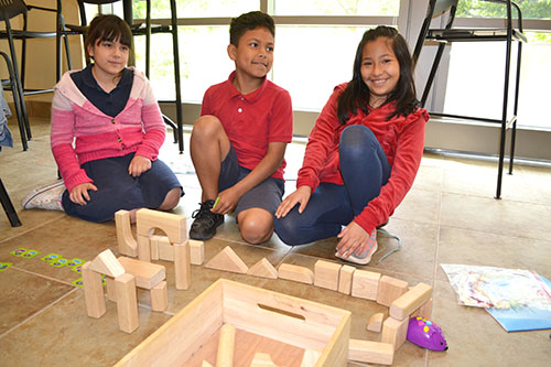 IPA 3rd graders watch as their mouse robot navigates through their maze.