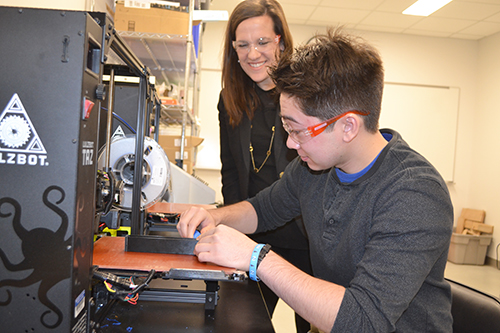 Holly Golecki (left) watches as BioE senior Kyle Ritchie prepares to cast a catheter in the mold he designed. 