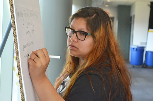  Nancy Rodriguez, the Sarah E. Goode STEM Academy's post-secondary coach, adds some ideas to her team's Action Plan.