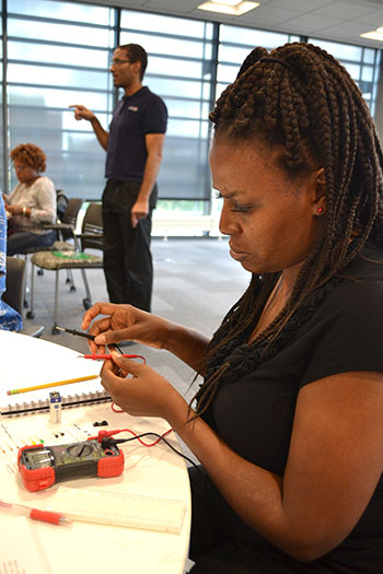 Lillian Perteete, Chicago Vocational Career Academy’s instructional technology teacher, prepares to test her circuit.   