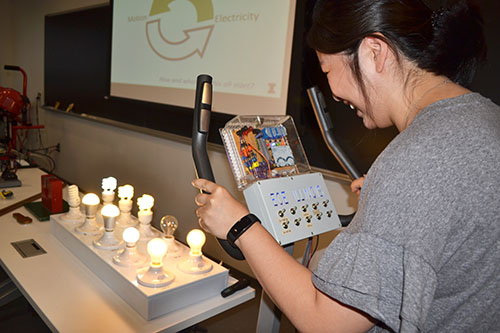 Pedaling a stationary bike, Elizabeth Ohr, Urbana High School Science teacher, produces enough current to light up all the bulbs but one.