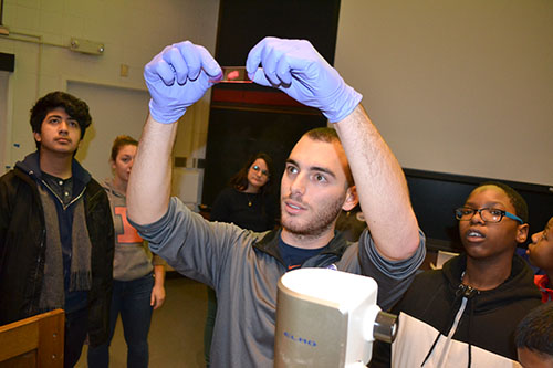 An AMS grad student shows a slide containing one of the materials they work with in their lab.