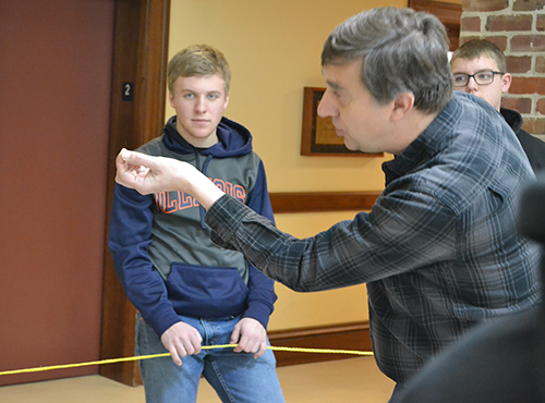 Joe Muskin illustrates the size of a "nanometer" compared to the diameter of the "hair," which is the inside of the rope circle.