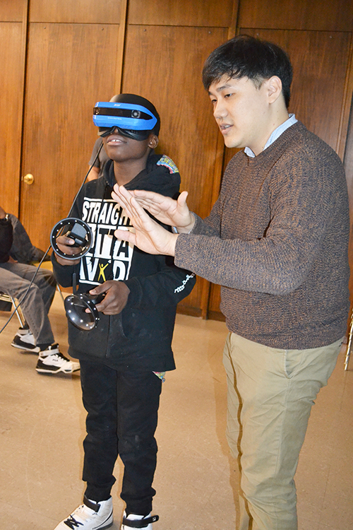 Kisung Kang interacts with a Franklin STEAM Studio student who's experienceing  Virtual Reality during one of the school's field trips to MRL. 