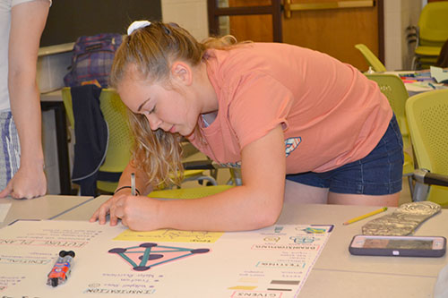 A camper puts some finishing touches on her team's poster.