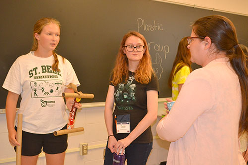 During Friday's poster session, Madelyn Torrance (left) exhibits her team's prototype, made with cardboard.