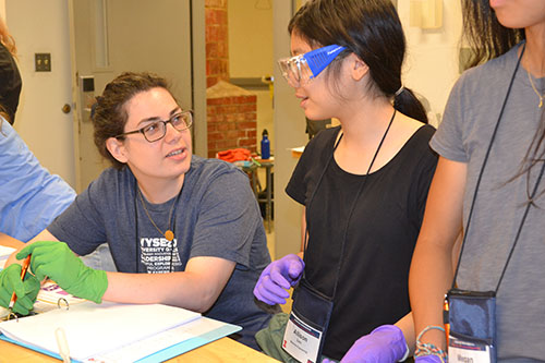 GLAM camper Allison Lau (center) interacts with MatSE grad student Jillian Carbono during an activity.