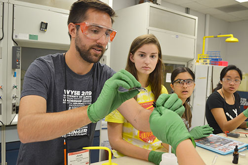 Grad student Josh Leveillee demonstrates to campers how to make a solar cell.