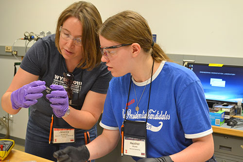 Jessica Krogstad works with a student creating a solar cell.