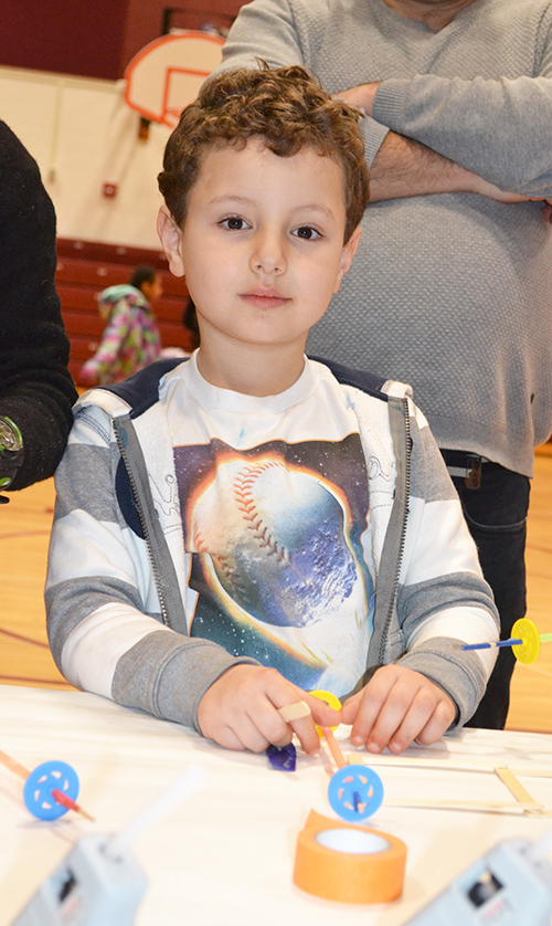 A STEAM Night visitor creates a rubberband helicopter.