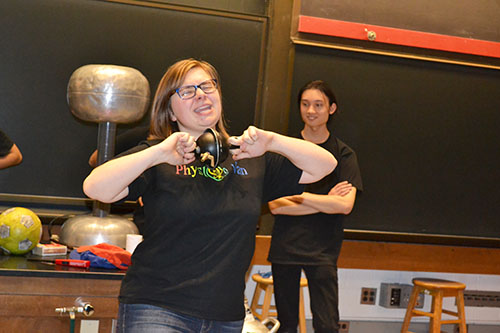 Spencer Hulsey tries to pull apart a pair of evacuated Magdeburg hemispheres:  the air has been sucked out, causing a vacuum.