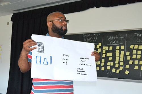 Vernon Rogers, the Diverse Learner Instructor at Sarah E. Goode STEM Academy, shows off his team’s poster about students’ perceptions of STEM, an activity during the first week of the institute.