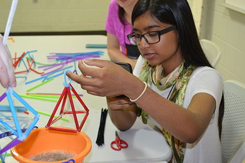 A high schooler takes a photo of the unique bubble her structure made (see below).