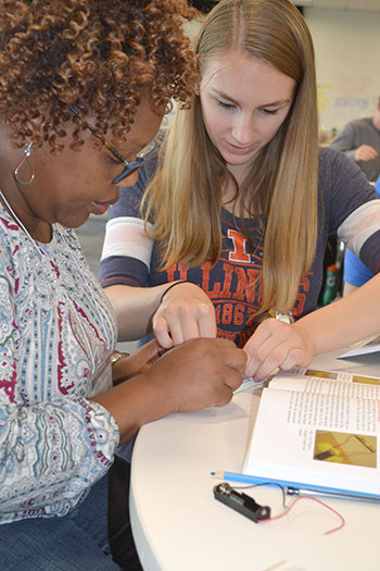 ECE student Maddie Wilson helps Anita Alicea, the STEM integration specialist at Sarah E. Goode STEM Academy, with her breadboard.