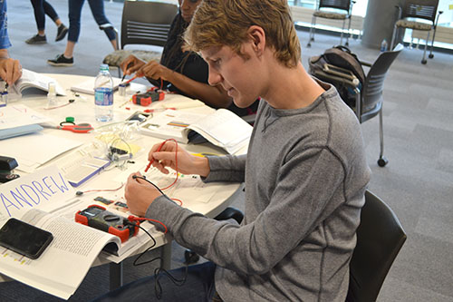 Andrew Wolmer, a Mahomet-Seymour alum and current Illinois secondary science teacher candidate, tests the voltage of the circuit he built.