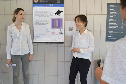 Two students present their incubator poster.