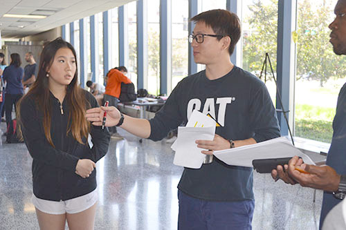 Electrical and Computer Engineering grad student Andy Yoon interacts with a team of students.