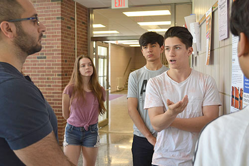 A Uni students discusses his team's research with judge Patrick Birbarah.