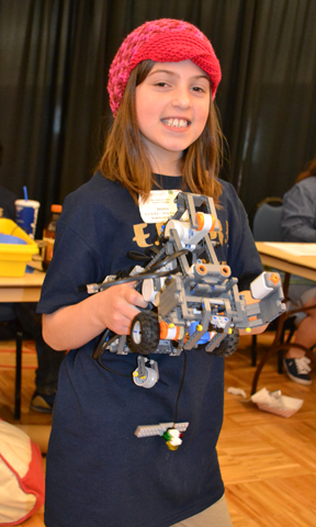 Youngster proudly displays the robot she helped build for the 4-H Robotics competition.