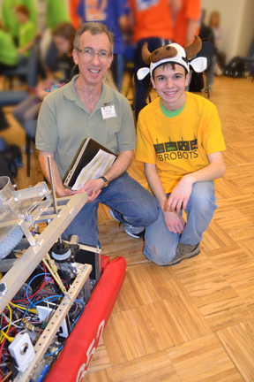 Bob Smith and 4-H robotics competitor pose by a robot.