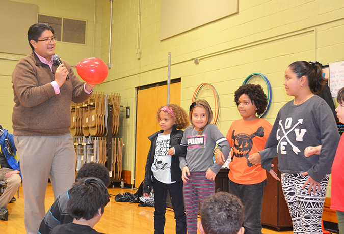I-MRSEC professor Joaquín Rodriguez-López explains to Cena y Ciencias visitors how they can stick a stick through a balloon without it popping.