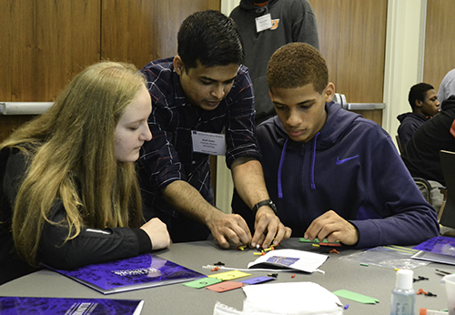 An Illinois student helps a team with their DNA structure.